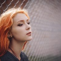 米哈云游内容编辑头像：年轻女性手持手机记录测试数据，背景是明亮的工作台